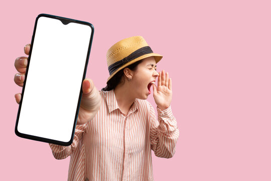 Advertising and smartphone apps. A young Caucasian woman in a straw hat shows a close-up cellphone with mock up and shouts to someone. Copy space. Concept of online feedback and shopping