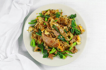 Stir-fried rice noodle with black soy sauce and pork and kale. Asian food style, ( Pad See-Ew ).