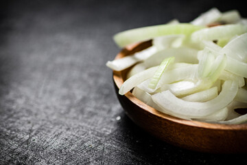 Chopped onions in a wooden plate. 