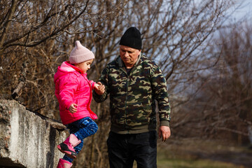 Fototapeta premium Senior man with his granddaughter. Child and grandpa outdoors. Benefits of getting older