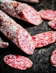 Sliced delicious salami sausage. On a black background.