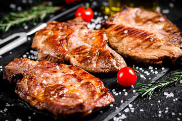 Grilled pork steak with cherry tomatoes and rosemary. 