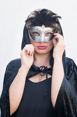 Mysterious Girl in a black cloak and a mardi gras steampunk black mask