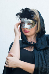 Mysterious Girl in a black cloak and a mardi gras steampunk black mask