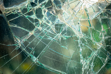 Texture of cracked glass close-up as a background. Broken car windshield. The car got a big hole in the windshield, an accident.