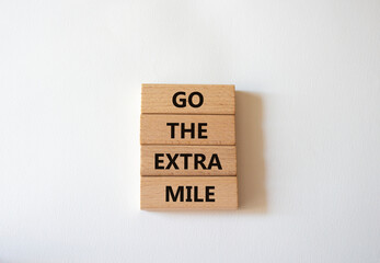 Go the extra mile symbol. Wooden blocks with words Go the extra mile. Beautiful white background. Business and Go the extra mile concept. Copy space.