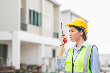 Asian attractive woman worker using walkie talkie on a construction site. woman at work
