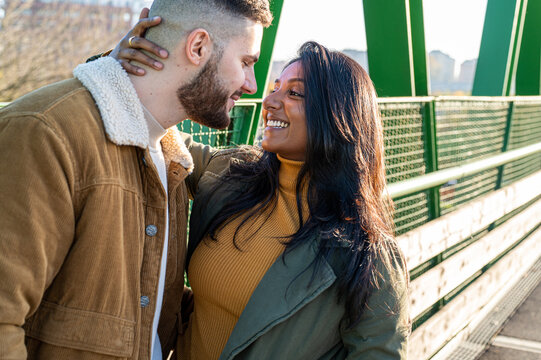 Young lovers cuddling, young Indian woman with her boyfriend having tender and romantic moment outside