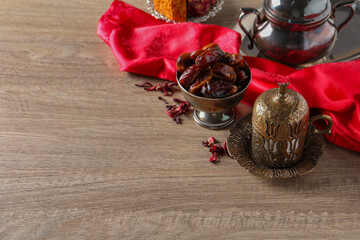 Tea and date fruits served in vintage tea set on wooden table, space for text