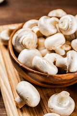 Mushrooms in a bowl on a cutting board. 