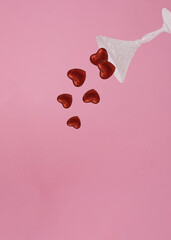 Shiny glass dropped  Red glitter heart. Minimal love concept. Valentine's Day love concept on pink background.