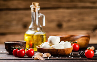 Mozzarella cheese on a plate on a table with tomatoes and spices. 