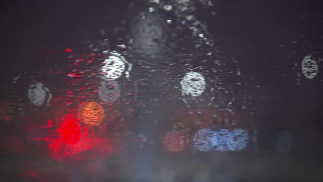 The camera moves along the wet windshield with a clumsy sway. It's raining.