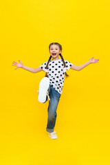 A teenage girl in a very good mood and a joyful smile on a yellow background.