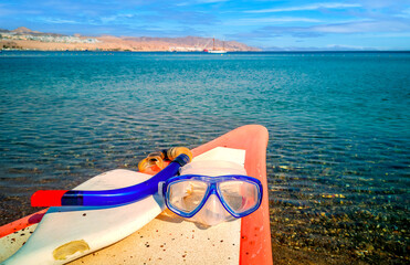 Morning at sandy beach of the Red Sea with kayak boat and snorkel equipment , Middle East - 563580663