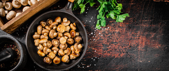 Frying pan with fried small mushrooms with parsley. 