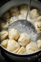 Dumplings are boiled in boiling water in a saucepan. 