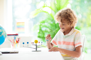 Child with solar system model. Kids planetarium.