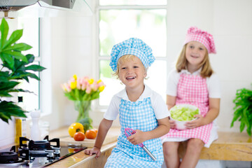 Kids cook in white kitchen. Children cooking.