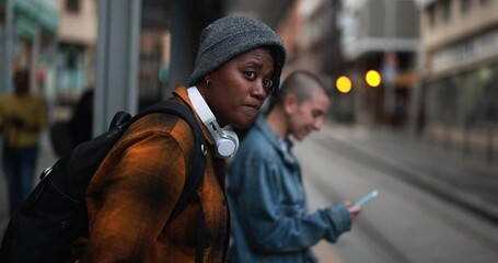 Young multiracial women waiting at the tram station - Focus on the african girl - Powered by Adobe