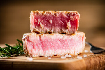 A piece of grilled tuna on a cutting board. 