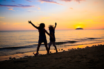 Fototapeta premium Child playing on ocean beach. Kid at sunset sea.