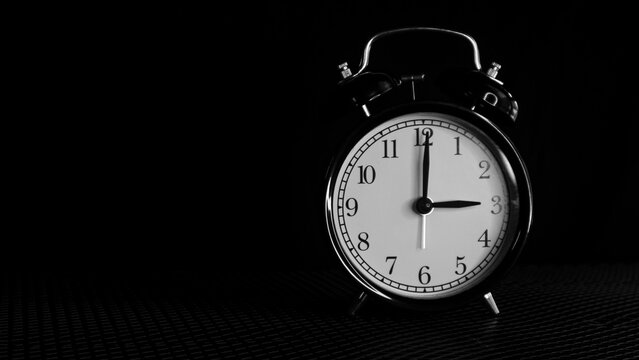 Background photo of an alarm clock showing 3:00