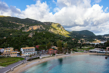 Famous Paleokastritsa beach and village on Corfu island, Greece. Picturesque seashore with turquoise crystal water, pebble beach Agios Spiridon, mountains and cliffs