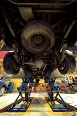 Car on hydraulic lift in auto repair shop