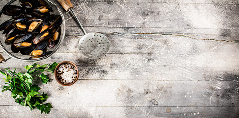 Delicious boiled mussels in a colander on the table. 