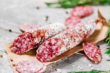Pieces of salami sausage with sprigs of rosemary. 