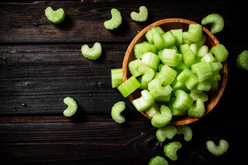 Sliced fresh celery. On a dark wooden background.