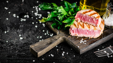 Fototapeta Grilled tuna steak on a parsley cutting board.  obraz