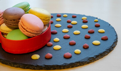 Macaroons in a red heart box and chocolate flakes on a slate plate