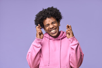 Happy African American teen guy crossing fingers making wish or feeling nervous. Smiling funny...
