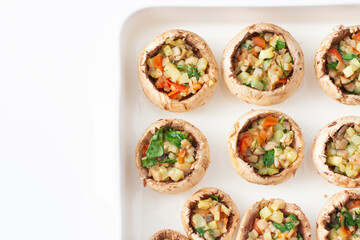 Stuffed mushrooms with vegetables on a baking dish.