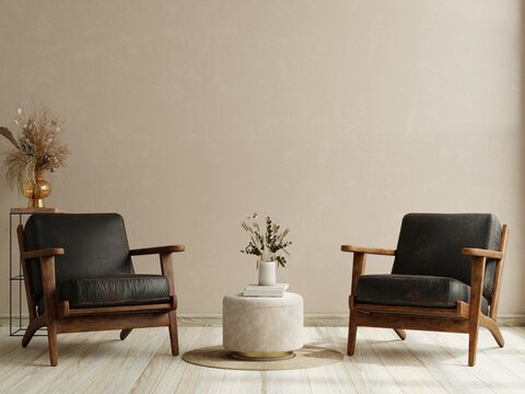 Living room with two leather armchair on empty cream color wall background.