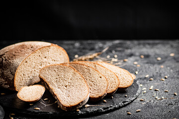 Slices of fresh bread on a stone board. 