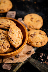 Cookies with pieces of milk chocolate on a cutting board. 