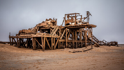 The rusted remains of an abandoned oil drilling rig between Henties Bay and Torra Bay, Skeleton Coast, Namibia. - obrazy, fototapety, plakaty