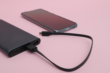 Powerbank charging a smartphone. Mobile phone or smartphone battery charging from portable...