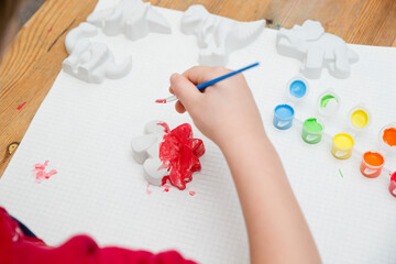 Obraz na płótnie Canvas Child painting a dinosaur. A tool for preschool education or kindergarten. Designed for sensory and movement training. Montessori-type occupational therapy for autistic children. 