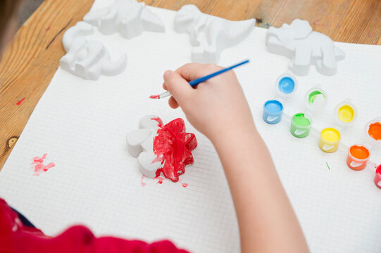 Child painting a dinosaur. A tool for preschool education or kindergarten. Designed for sensory and movement training. Montessori-type occupational therapy for autistic children.
