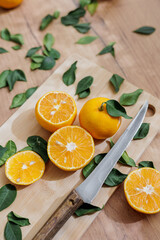 top view of oranges on wooden chopping board. sliced orange citrus fruits and knife with wooden handle. healthy healthy food, fresh juice, vitamins. place for text