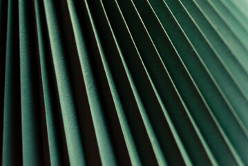 Minimalistic green dynamic background with diagonal lines, curtains, abstract dark geometric shape from fabrics with soft shadow background, top view	