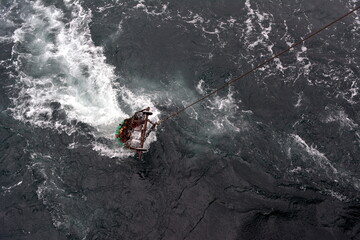 The fishing net with a catch rises to the trawler
