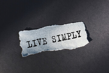 A piece of paper on gray backround with the text LIVE SIMPLY