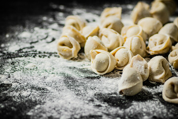 Raw dumplings on the table with flour.