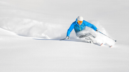 Skier in powder during a carving turn - 563616054