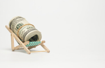 A picture of fake cash at the folding beach chair on copyspace white background. Retirement and...